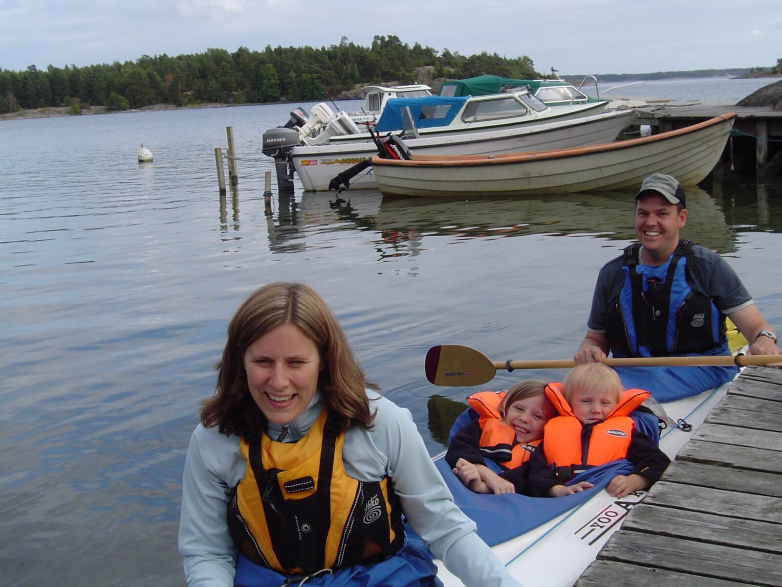 Familj i kajak vid bryggan