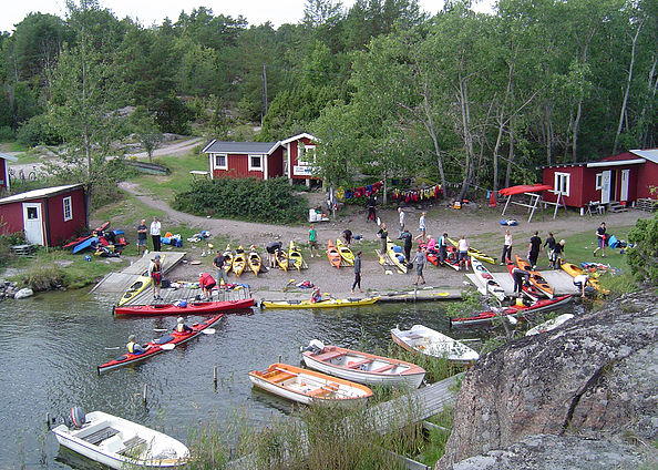 Kajaker och badgäster vid bryggan