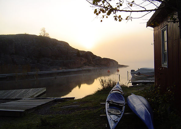 Kajaker på stranden i kvällsljus
