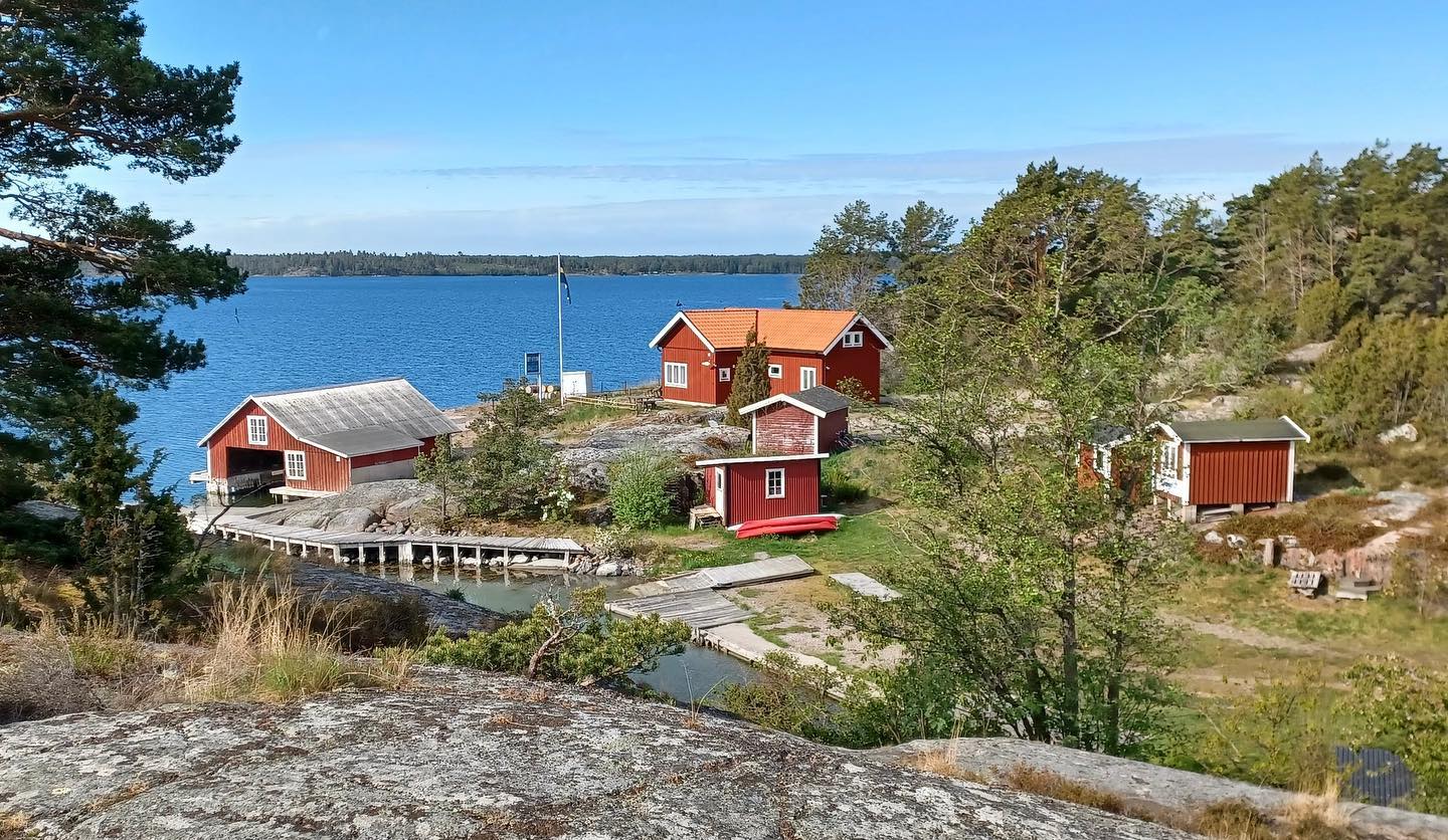 Röda sjöbodar vid bryggan i Tyrislöt